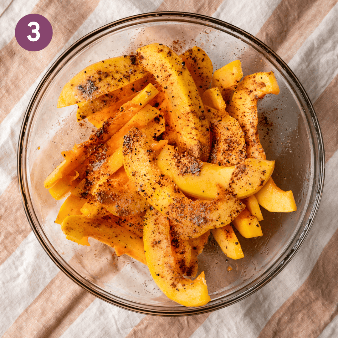 Seasoned pumpkin wedges in a glass bowl.
